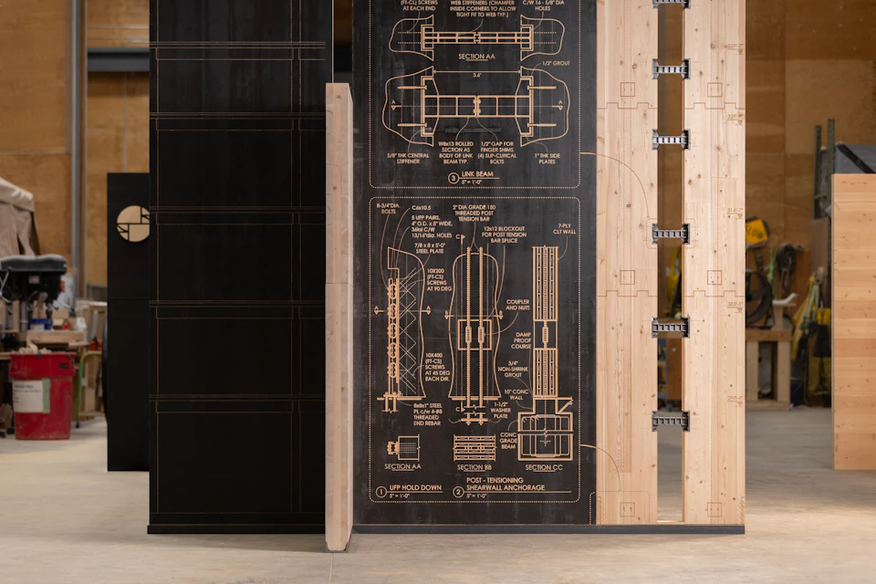 CNC-routed structural diagrams beside the steel links joining the pavilion’s CLT wall panels.