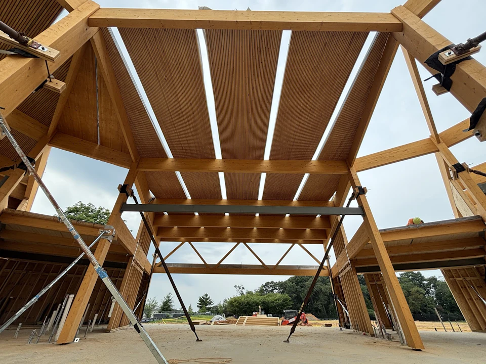 Douglass Community Center glulam columns, beams and roof panels during erection, viewed from below.