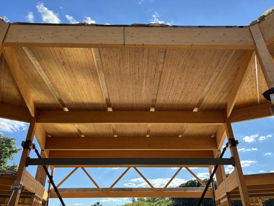 Douglass Community Center timber roof decking spanning between glulam beams during construction.