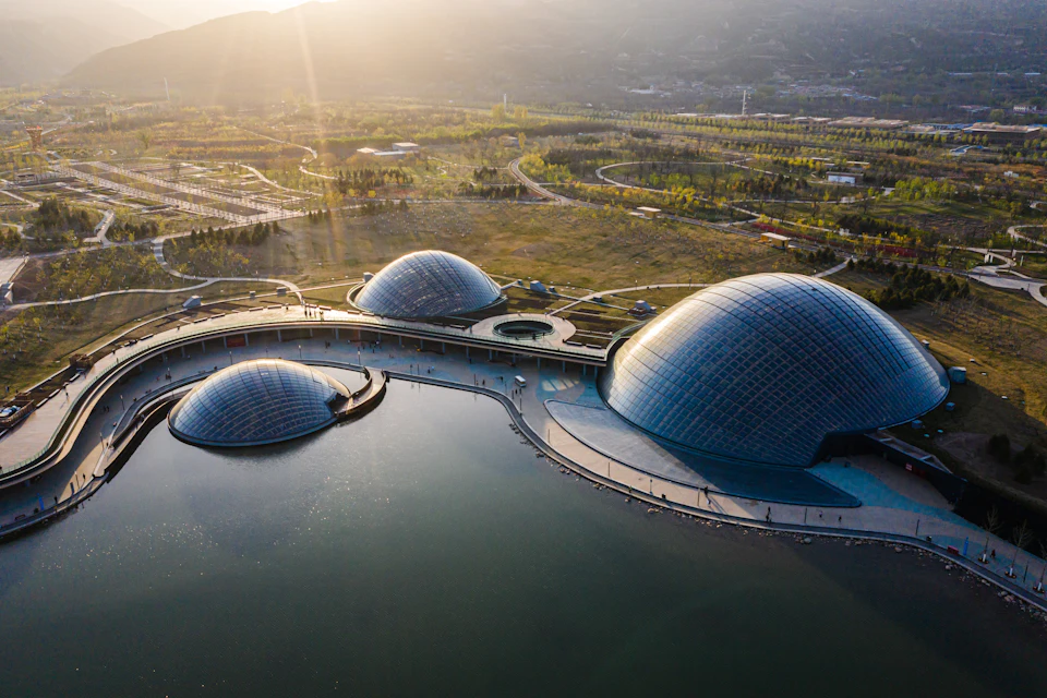 Aerial view of three timber domes beside a lake