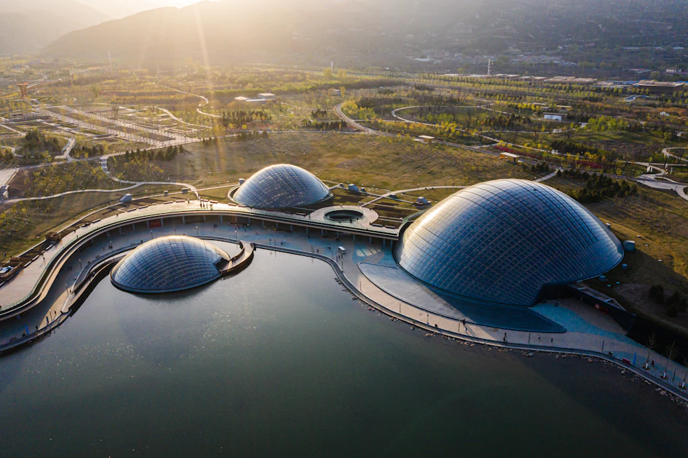 Aerial view of three timber domes beside a lake