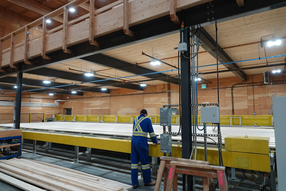 Worker beside a wood panel in the fabrication shop for Lakeview Office Building