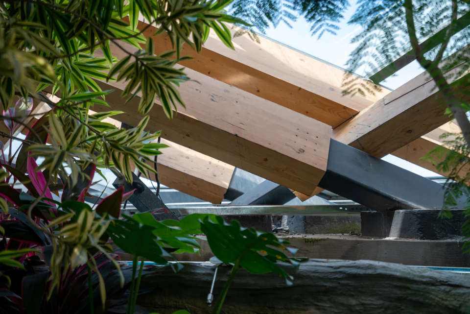 Wood beams and dark steel frame among plants at Taiyuan Botanical Garden