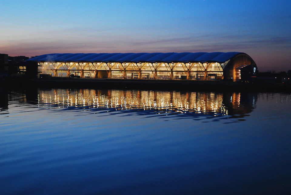 Richmond Olympic Oval reflected in water at dusk