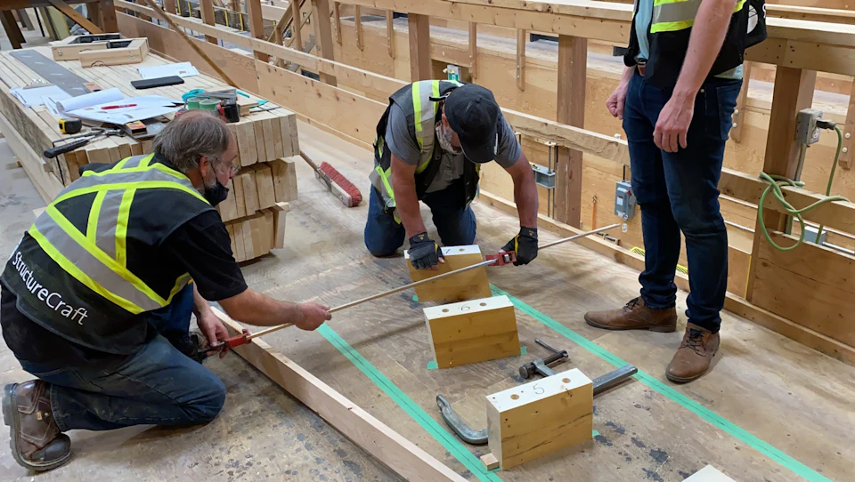 Workers laying out the spiral stair at KF Aerospace Centre