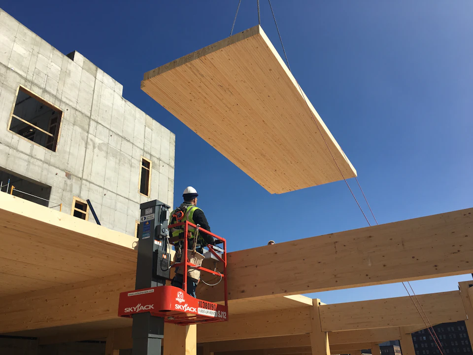 Wood floor panel suspended above workers at T3 Minneapolis