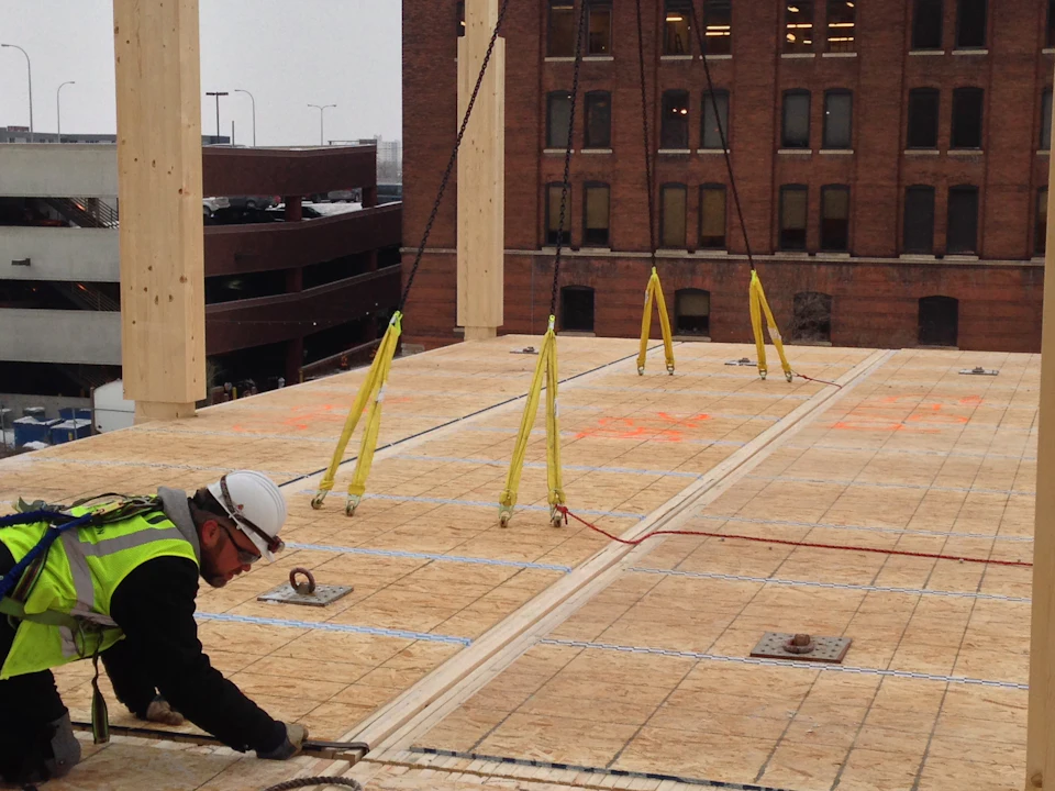 Workers fastening wood floor panels at T3 Minneapolis