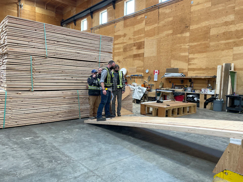 Stacked timber panels in the fabrication shop for KF Aerospace Centre