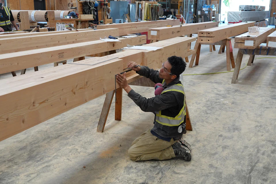 Worker assembling timber members for KF Aerospace Centre