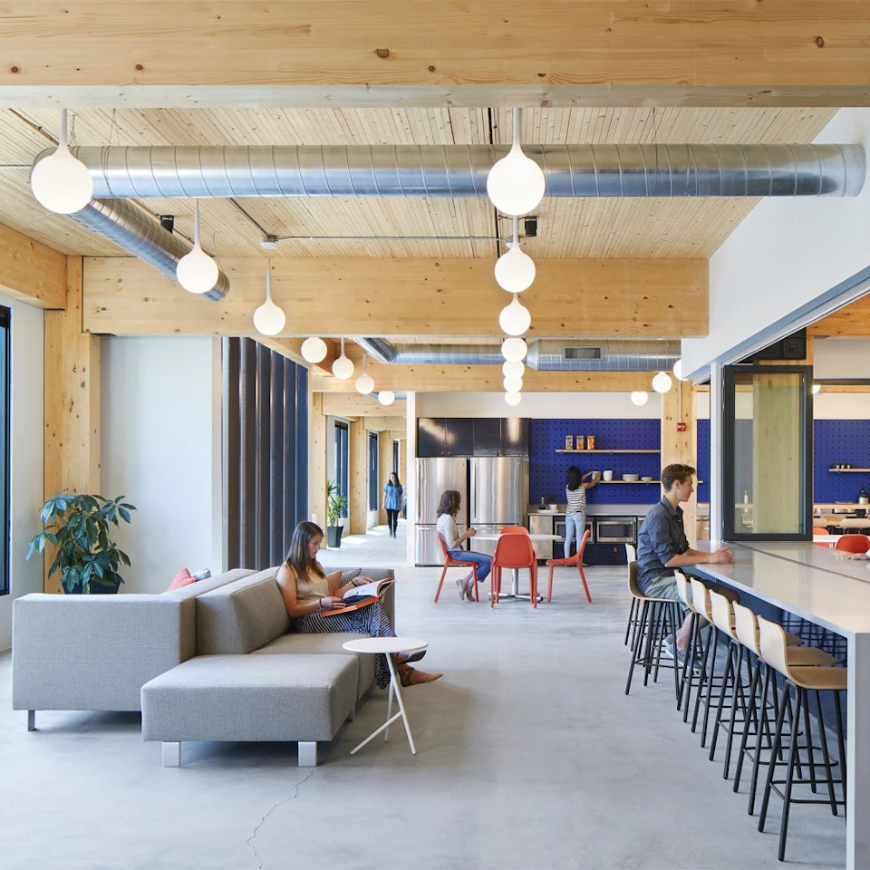 Long office lounge beneath exposed wood at T3 Minneapolis