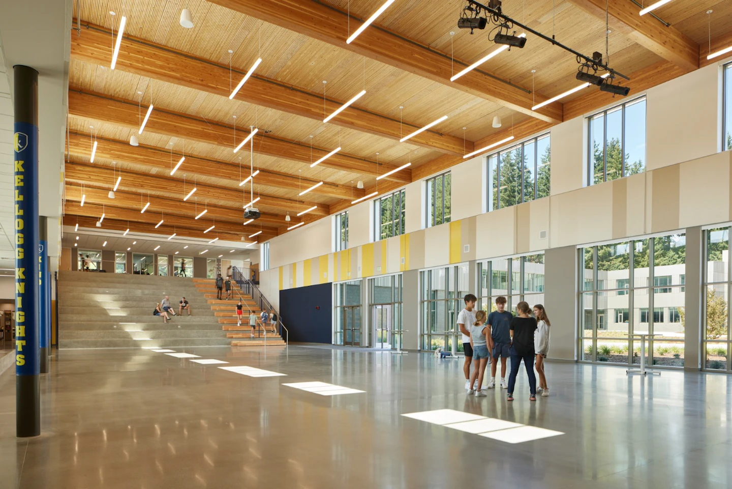 School commons beneath an exposed timber ceiling at Kellogg Middle School