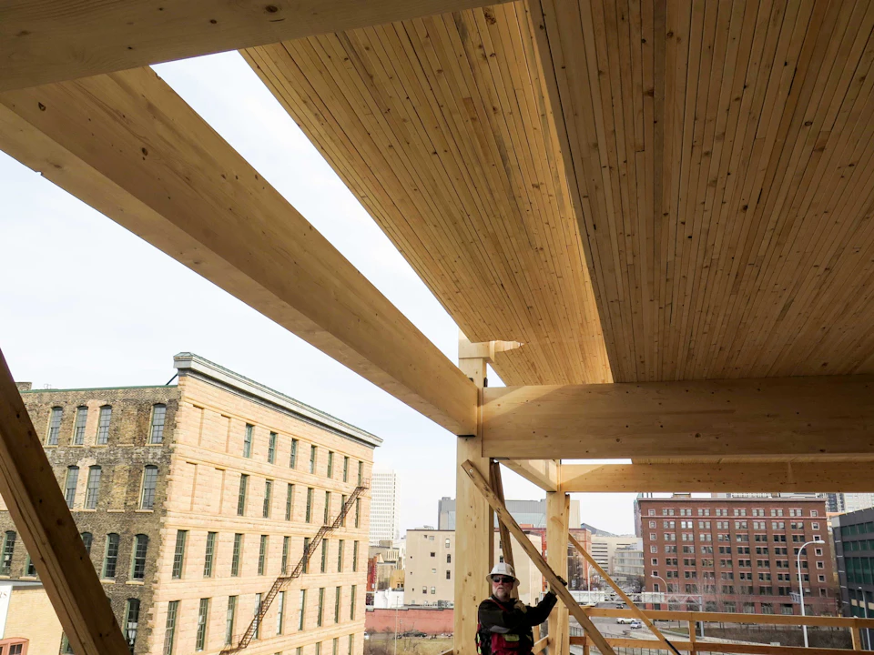 Worker beneath installed wood floor panels at T3 Minneapolis