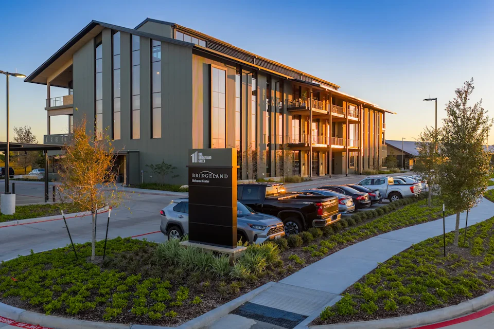 Street-level view of One Bridgeland Green, showing the projecting roof and timber balconies.