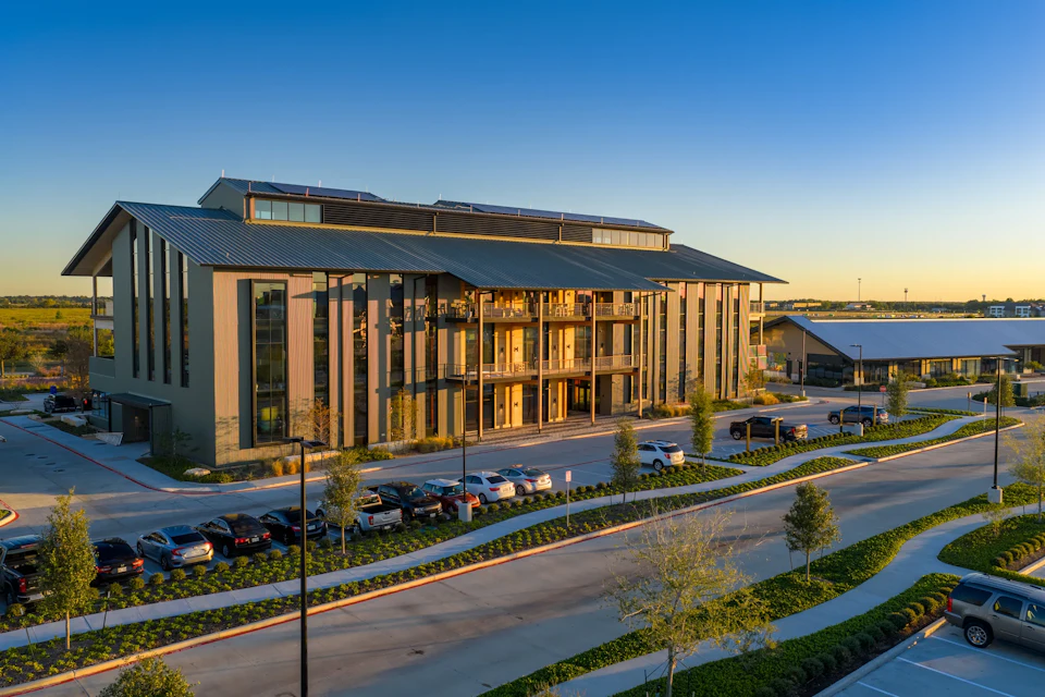 One Bridgeland Green exterior with its gabled roof and glazed timber facade at sunset.