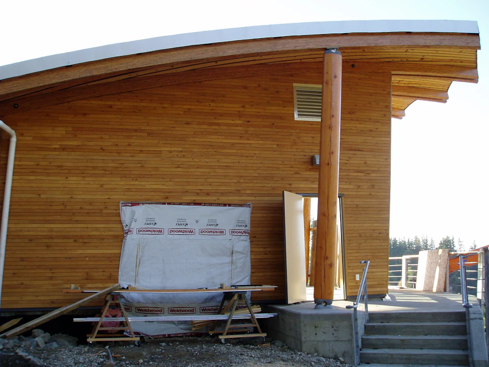 Curved wood exterior wall beside steps at Rix Centre for Ocean Discoveries