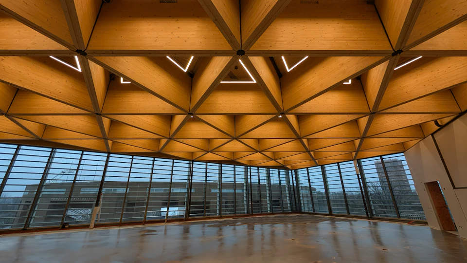 Finished hall beneath a geometric wood ceiling at Princeton University Commons