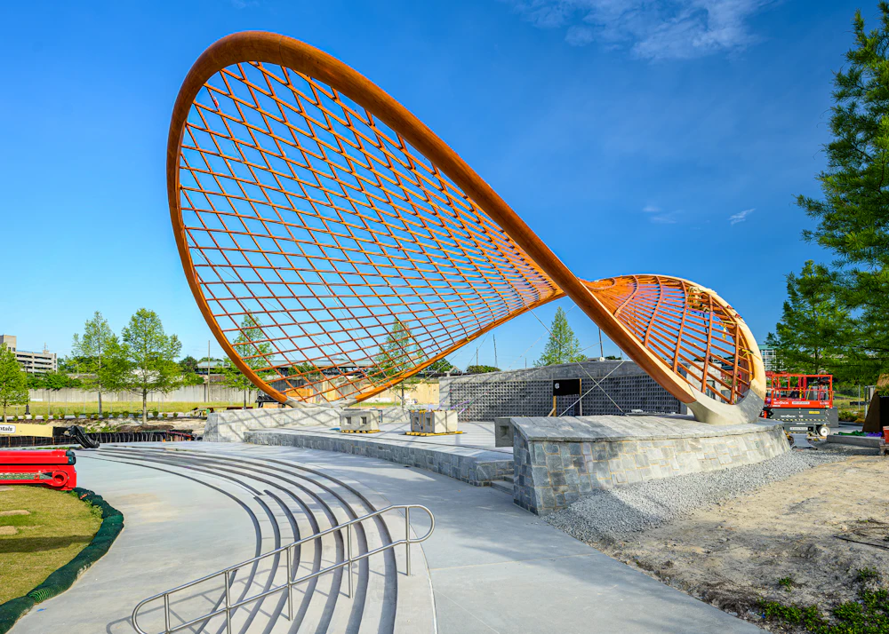 Sculptural wood pavilion beside outdoor seating