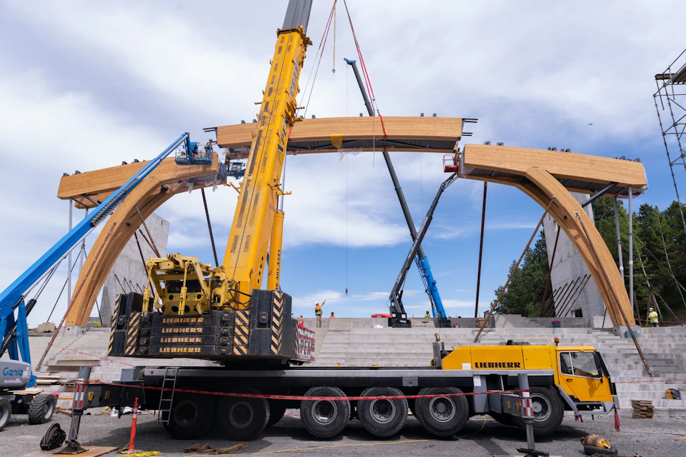 Curved arena arch being lifted into place